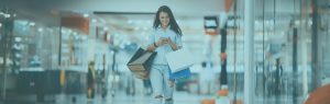 Woman with shopping bags looking at phone.